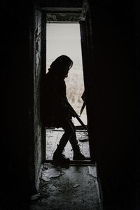 Silhouette man standing against door in building