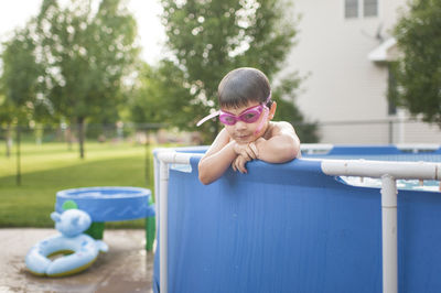 Portrait of boy wearing swimming goggles in wading pool