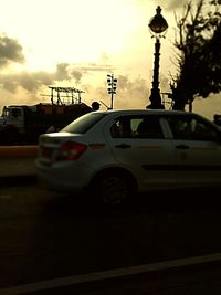 Car on street against sky during sunset