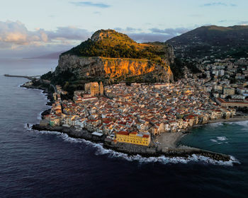 High angle view of townscape by sea against sky