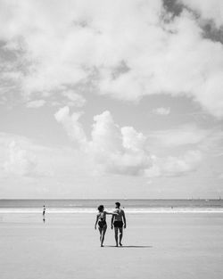 People at beach against sky