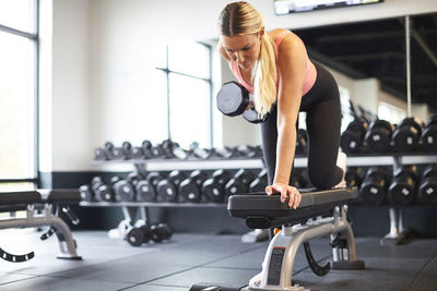 A blonde woman working out in a gym.