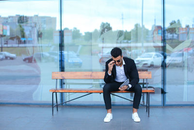 Full length of man sitting on chair at window