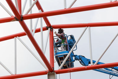 Low angle view of people on metal structure