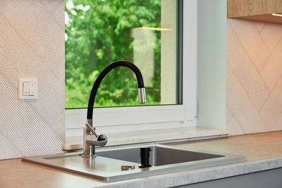 Interior of a modern kitchen with sink near window