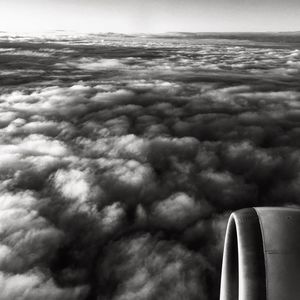 Airplane wing against cloudy sky