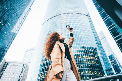 Low angle view of woman standing against sky