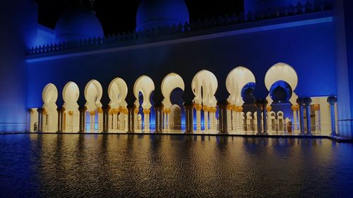 Reflection of illuminated building in water at night