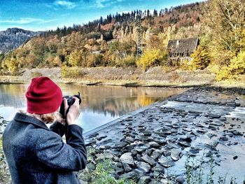 Rear view of man standing by lake