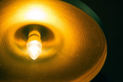 Low angle view of illuminated light bulb against black background