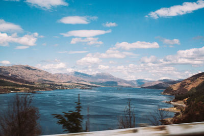 Scenic view of sea and mountains against blue sky