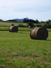 Hay bales on field against sky