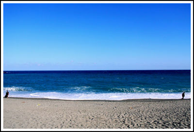 Scenic view of beach against blue sky