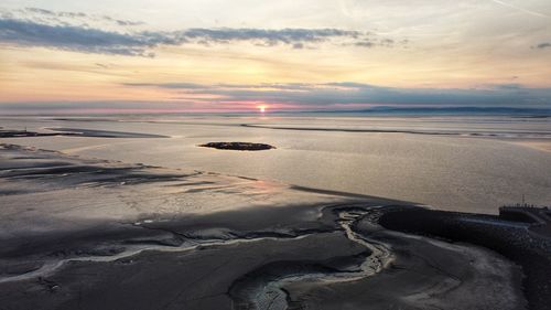 Scenic view of beach against sky during sunset