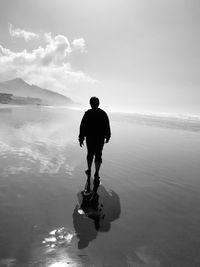 Rear view of man walking on beach