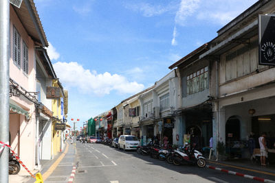 City street by buildings against sky