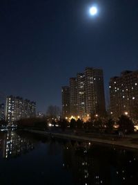 Illuminated buildings in city against sky at night