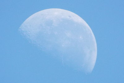 Low angle view of moon against clear blue sky