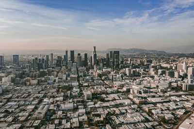 Aerial view of buildings in city against sky