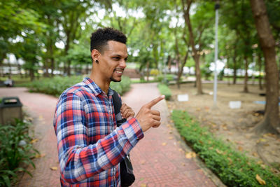 Young man using smart phone while standing outdoors