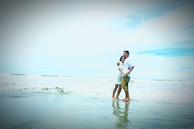 Full length of man standing on beach against sky