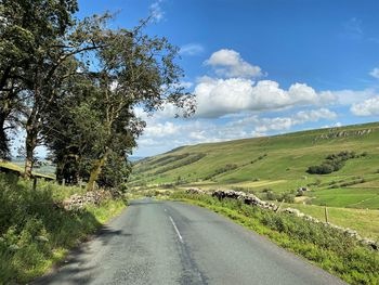 Empty road along countryside landscape