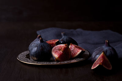 Close-up of fruits on table against black background