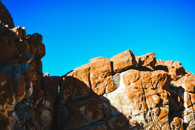 Low angle view of rock formations against blue sky