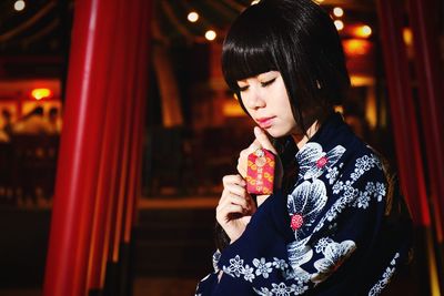 Close-up of young woman in kimono at night