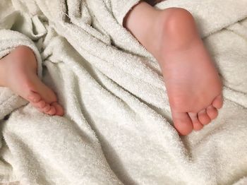Low section of baby feet on bed