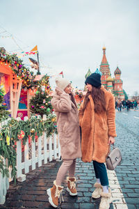 People standing outside temple in city during winter