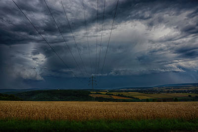 Scenic view of field against storm clouds