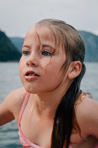 Close-up of wet girl at beach against sky