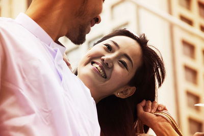 Close-up of smiling friends against building