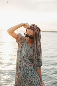 Woman standing at beach against sky