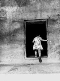 Full length of woman standing on wall