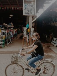 Side view of woman sitting on bicycle