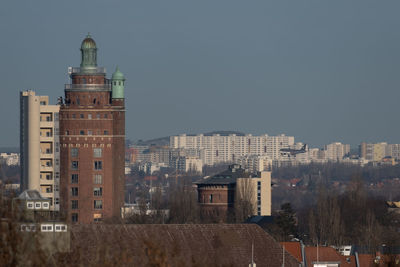 Buildings in city against clear sky