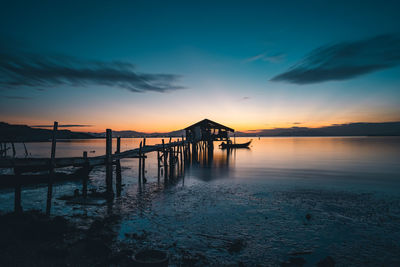 Pier over sea against sky during sunset