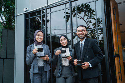 Portrait of smiling couple standing against building