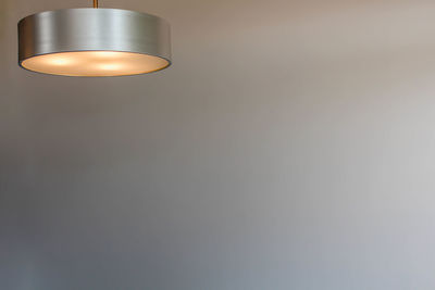 Low angle view of illuminated pendant light on wall