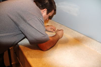 High angle view of carpenter measuring wooden table