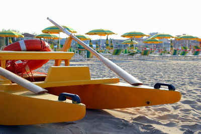 Boat moored on beach against clear sky