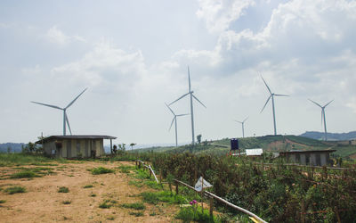 Windmills on field against sky