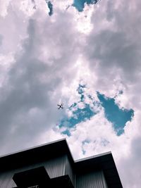 Low angle view of airplane flying against sky