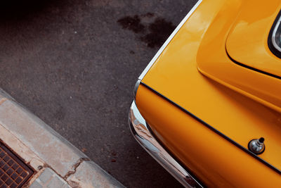 Cropped image of orange car on road