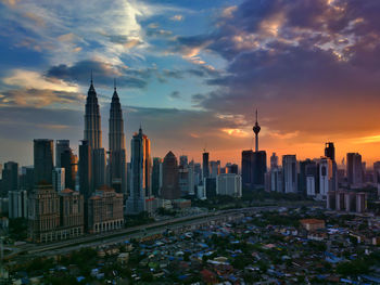 Skyscrapers in city at sunset