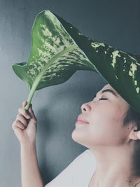 Close-up of young woman holding a leaf