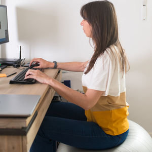 Side view of woman using mobile phone at home