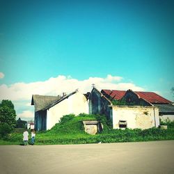 House by barn against sky